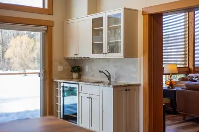 a kitchen with white cabinets and a sink at Elk River Estate by Fernie Central Reservations in Fernie