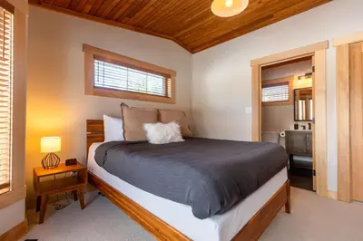a bedroom with a bed and a window at Elk River Estate by Fernie Central Reservations in Fernie