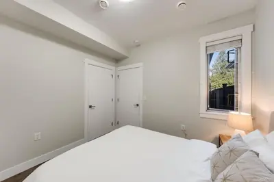 a white bedroom with a bed and a window at Private Entrance Suite Near Deer Lake & Metro in Burnaby