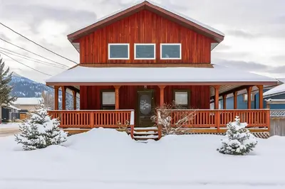 a red house with snow in front of it at Huckleberry Lodge by Fernie Central Reservations in Fernie