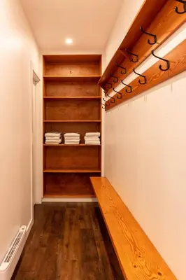 a walk in closet with wooden shelves and a wooden bench at Huckleberry Lodge by Fernie Central Reservations in Fernie