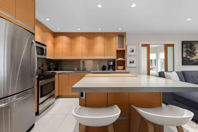 a kitchen with wooden cabinets and a counter top at 2BR + Sofabed | Gables | Epic Village Location | Secure Parking | Stylish & Cozy in Whistler