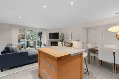 a kitchen and living room with a couch and a table at 2BR + Sofabed | Gables | Epic Village Location | Secure Parking | Stylish & Cozy in Whistler