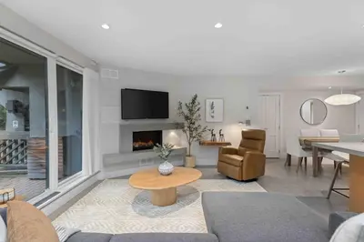 a living room with a couch and a table and a fireplace at 2BR + Sofabed | Gables | Epic Village Location | Secure Parking | Stylish & Cozy in Whistler