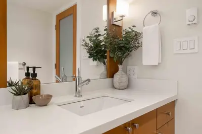 a white bathroom with a sink and a mirror at 2BR + Sofabed | Gables | Epic Village Location | Secure Parking | Stylish & Cozy in Whistler