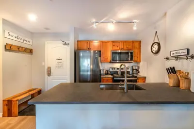 a kitchen with a sink and a refrigerator at 1BR+Sofabed | Deer Lodge | Epic Village Location | Covered Patio | Ski Locker | Fireplace | Parking in Whistler