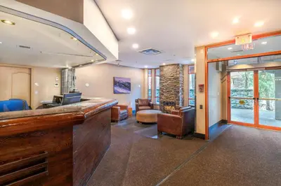 a lobby with a bar and a living room at 1BR+Sofabed | Deer Lodge | Epic Village Location | Covered Patio | Ski Locker | Fireplace | Parking in Whistler