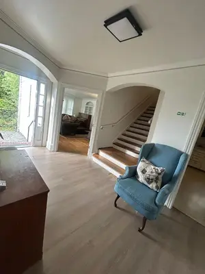 a living room with a blue chair and a staircase at Vancouver Guest House - Airport 10 Min - Free Parking & Fast Wi-Fi in Vancouver