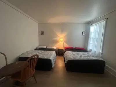 a room with two beds and a table with a lamp at Vancouver Guest House - Airport 10 Min - Free Parking & Fast Wi-Fi in Vancouver