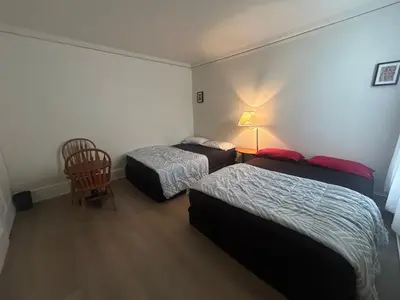a hotel room with two beds and a chair at Vancouver Guest House - Airport 10 Min - Free Parking & Fast Wi-Fi in Vancouver