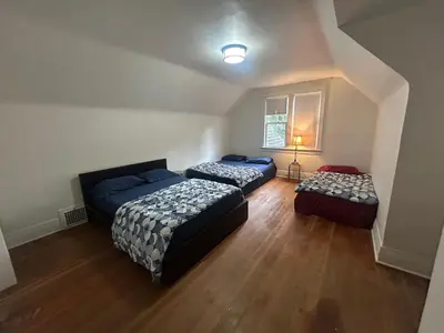 a bedroom with two beds and two ottomans at Vancouver Guest House - Airport 10 Min - Free Parking & Fast Wi-Fi in Vancouver