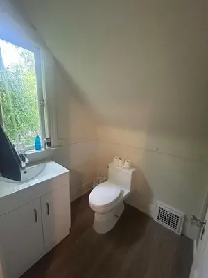 a bathroom with a toilet and a sink and a window at Vancouver Guest House - Airport 10 Min - Free Parking & Fast Wi-Fi in Vancouver