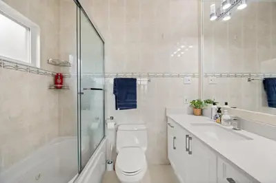 a bathroom with a toilet and a sink and a shower at Modern & Bright 5BR Family Home in Vancouver