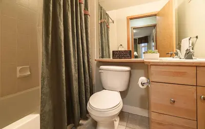 a bathroom with a toilet and a sink and a shower at Cozy 2BR-5BD Suite - Mountain Views - Htd Parking in Canmore