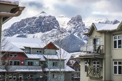 a group of houses in front of a mountain at Cozy 2BR-5BD Suite - Mountain Views - Htd Parking in Canmore