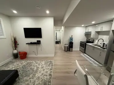 a living room with a television and a kitchen at ideal place in Prince George