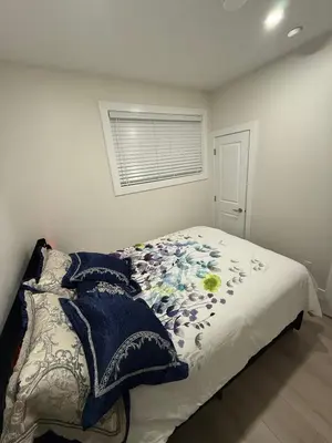 a bedroom with a bed with a blanket and a window at ideal place in Prince George