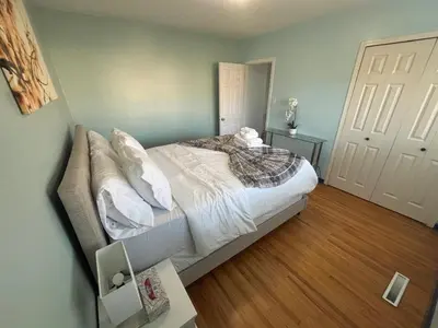 a bedroom with a bed with white sheets and pillows at Charming Bright 3BR House - Upper Level Suite in Burnaby