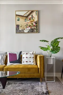a living room with a yellow couch and a picture on the wall at Stylish & Romantic Riverside Stay in Downtown in Calgary