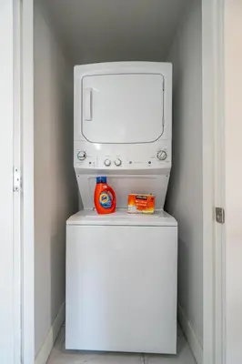 a television sitting on top of a white refrigerator at Cozy And Modern 2 Bedroom Along Bow River in Downtown in Calgary
