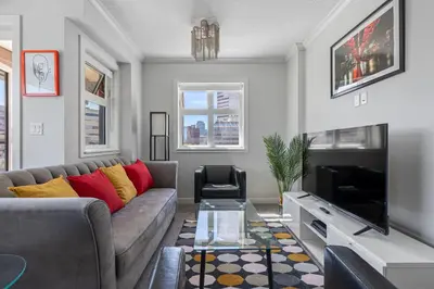 a living room with a couch and a tv at Delightful 2 BR And 2 Bath Water View in Downtown in Calgary