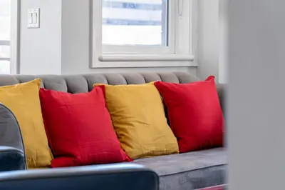a couch with four red and yellow pillows on it at Delightful 2 BR And 2 Bath Water View in Downtown in Calgary