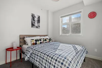 a bedroom with a bed and a clock on the wall at Waterfront 2 Beds And 2 Bath Downtown Urban Escape in Calgary