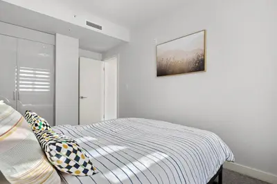 a bedroom with a bed and a picture on the wall at Waterfront 2 Beds And 2 Bath Downtown Urban Escape in Calgary