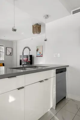 a kitchen with white cabinets and a sink at Waterfront 2 Beds And 2 Bath Downtown Urban Escape in Calgary