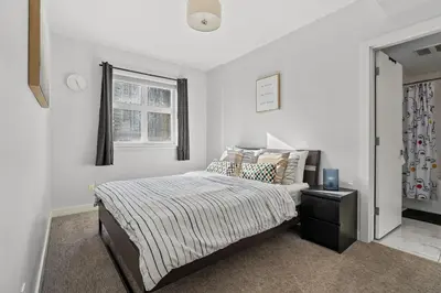 a white bedroom with a bed and a window at Waterfront 2 Beds And 2 Bath Downtown Urban Escape in Calgary