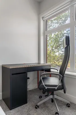 an office desk with a chair and a window at Vibrant Stylish, Cozy Waterfront Downtown in Calgary