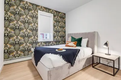 a bedroom with a bed and a mirror at Lovely 3BR unit in the heart of Calgary in Calgary
