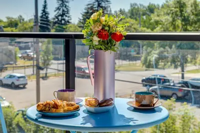 a table with a vase with flowers and pastries on it at Lovely 3BR unit in the heart of Calgary in Calgary