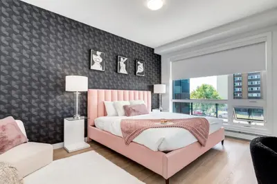 a bedroom with a pink bed and a window at Modern 3BR unit in the heart of Calgary in Calgary