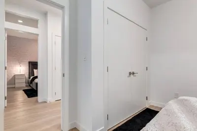 a bedroom with white walls and a white closet at Modern 3BR unit in the heart of Calgary in Calgary