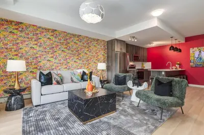 a living room with a couch and chairs and a kitchen at Cozy 3BR unit with Arcade in the heart of Calgary in Calgary