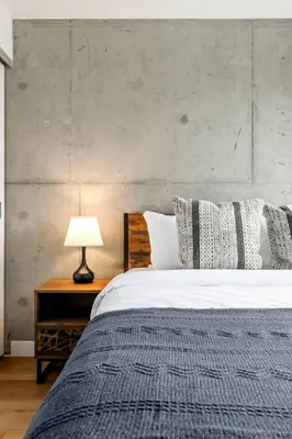 a bedroom with a bed and a table with a lamp at Modern 1BR City Escape with Balcony near DT Calgary in Calgary