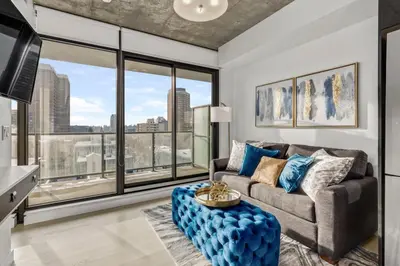 a living room with a couch and a large window at Spacious and Stylish Modern Condo in Calgary in Calgary