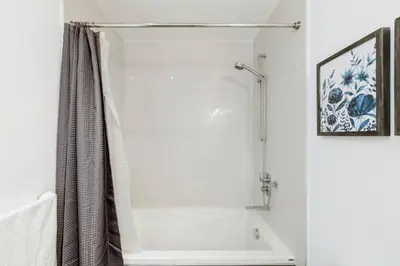 a white bathroom with a shower and a bath tub at Spacious and Stylish Modern Condo in Calgary in Calgary
