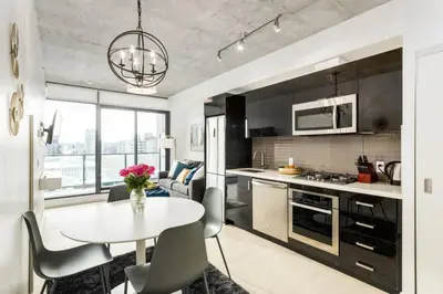 a kitchen and living room with a table and chairs at Spacious and Stylish Modern Condo in Calgary in Calgary