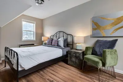 a bedroom with a bed and a chair at Cozy and Stylish Stay in Mountain View Condo in Canmore