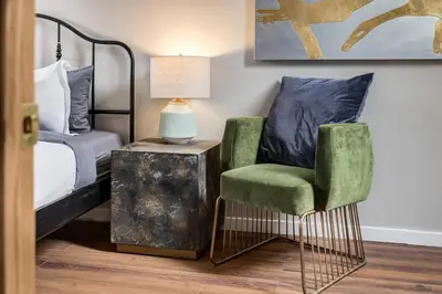 a bedroom with a bed and a chair and a lamp at Cozy and Stylish Stay in Mountain View Condo in Canmore