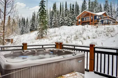 a hot tub on a balcony with a log cabin at Rockies Escape Skiing Hiking and Private Hot Tub in Golden