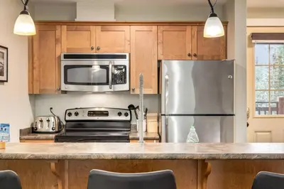 a kitchen with a stainless steel refrigerator and microwave at Rockies Escape Skiing Hiking and Private Hot Tub in Golden