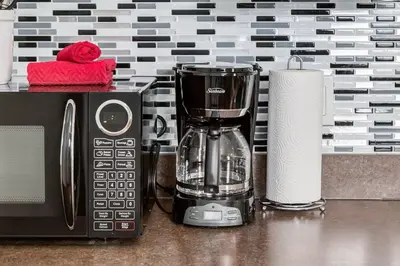 a blender next to a microwave and a roll of paper towels at The Cutest Condo in Canmore and Banff in Canmore