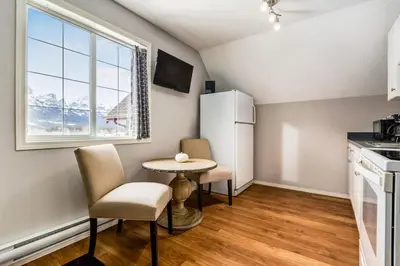 a kitchen with a small table and chairs and a window at Cozy getaway for exploring Canmore and Banff in Canmore