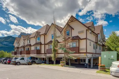 a large building with cars parked in a parking lot at Cozy getaway for exploring Canmore and Banff in Canmore