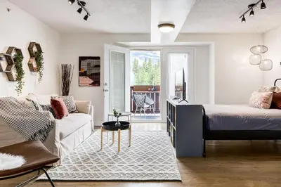 a bedroom with a bed and a living room with a couch at The Most Perfect Stay in Canmore with Mountain View in Canmore