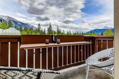 a balcony with a table and chairs and mountains at The Most Perfect Stay in Canmore with Mountain View in Canmore
