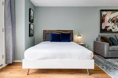 a bedroom with a large white bed and a couch at Stunning Mountain View Cozy Studio for Small Grp in Canmore